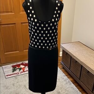 Sleeveless sweater dress.  Top is black with white dots. Dress bottom is black.